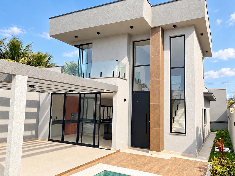 Fachada ensolarada da casa com piscina em Massagua�u