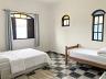 Quarto com duas camas de solteiro e janelas em arco