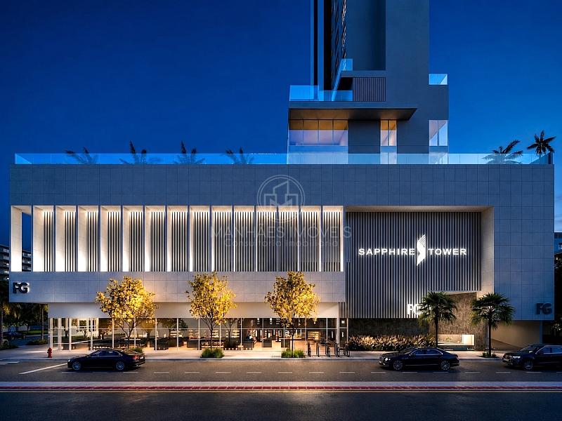 Fachada do embasamento iluminado � noite do Sapphire Tower com vitrines comerciais em Balne�rio Cambori�