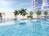 Piscina adulta ampla com deck molhado e palmeiras tropicais