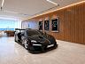 Superesportivo estacionado no living da mans�o suspensa com quadros dos circuitos de M�naco, Silverstone e Laguna Seca