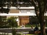 Fachada frontal contempor�nea do Aman vista atrav�s da pra�a arborizada 