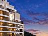 Perspectiva dos andares superiores da fachada do Aman ao p�r do sol, exibindo o p�-direito duplo do apartamento duplex e vista panor�mica para as montanhas 