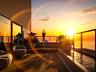 Pr�tica de yoga no deck de madeira do rooftop ao entardecer, com espelho d'�gua e horizonte do mar iluminado