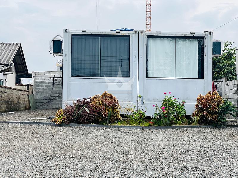 Fachada da unidade com janelas e jardim frontal