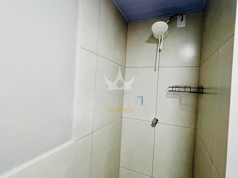 �rea de banho com chuveiro e paredes revestidas