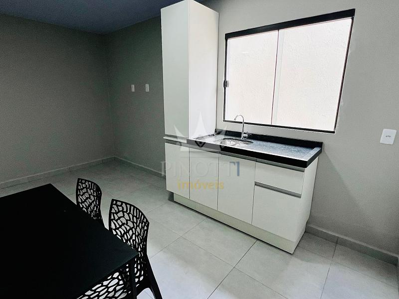 Cozinha com m�veis sob medida, bancada com pia e janela na kitnet semimobiliada