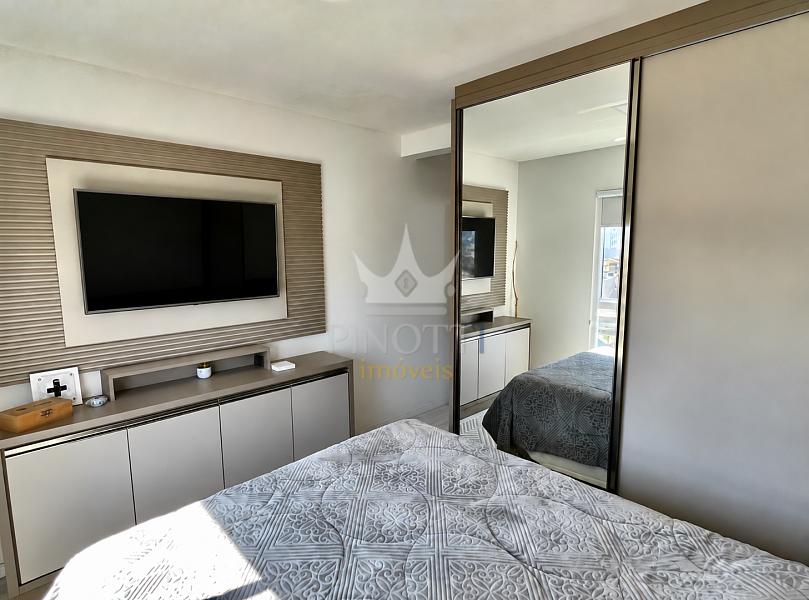 Dormit�rio de casal com painel de televis�o e arm�rio espelhado no apartamento em S�o Jo�o, Itaja�.