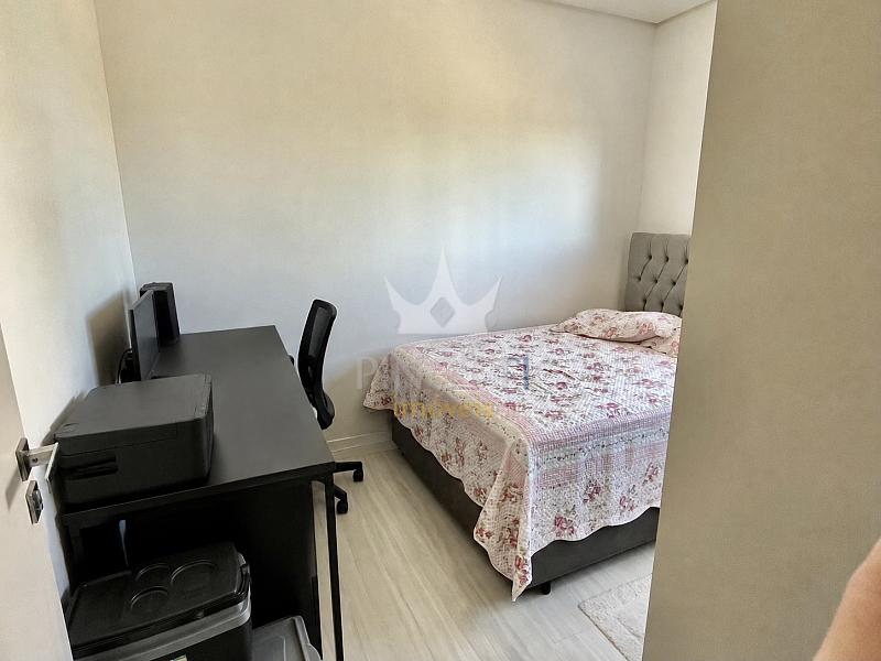 Dormit�rio com cama, mesa de trabalho e arm�rio no apartamento do Edif�cio Attualita, em Itaja�.
