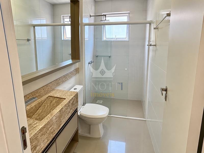 Banheiro com box de vidro, bancada e gabinete no apartamento do Edif�cio Attualita, em Itaja�.