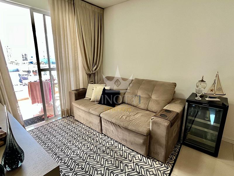 Sala de estar mobiliada, com sof� junto � janela e cortinas no Edif�cio Attualita, em Itaja�.