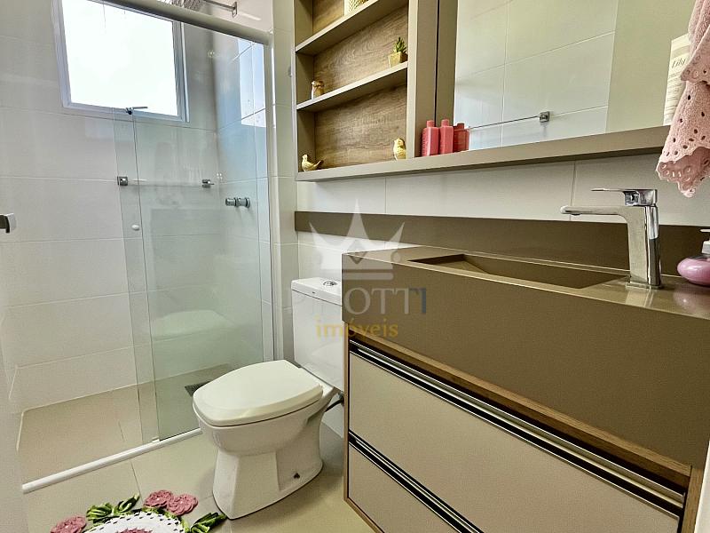 Banheiro com gabinete sob a bancada, espelho e vaso sanit�rio no apartamento em S�o Jo�o, Itaja�.